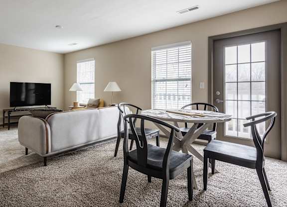 A living room with a white sofa, a black chair, and a television.