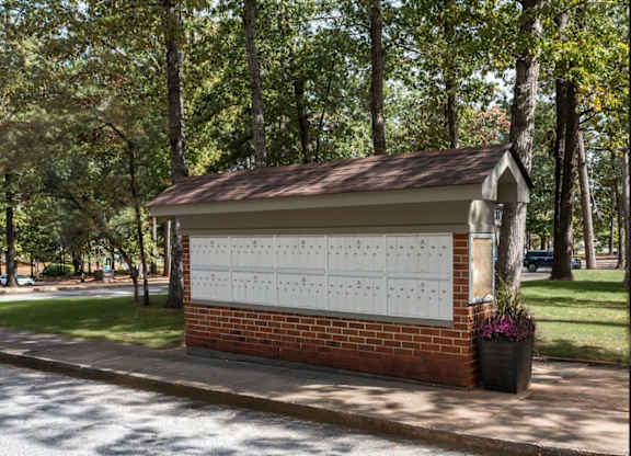 A small building with a calendar on the wall and a tree in front of it at Laurel Woods Apartments, South Carolina, 29607