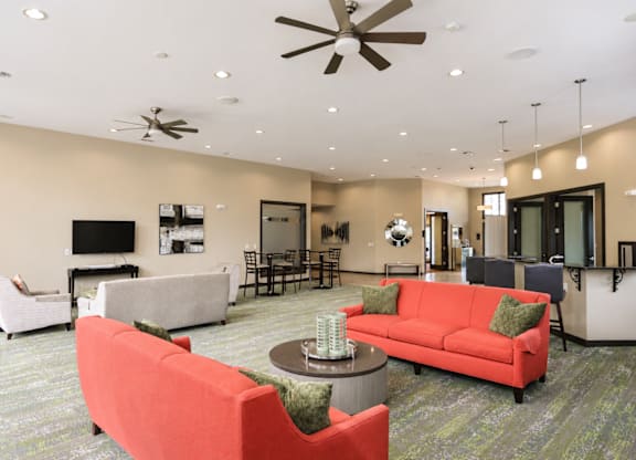 A living room with a red couch and a ceiling fan.