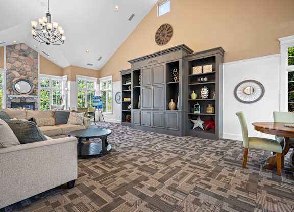 A living room with a stone wall and a large clock on the wallk at Timberlane Apartments, Peoria, Illinois