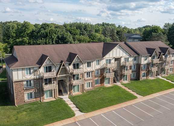 A large apartment complex with a parking lot in front.