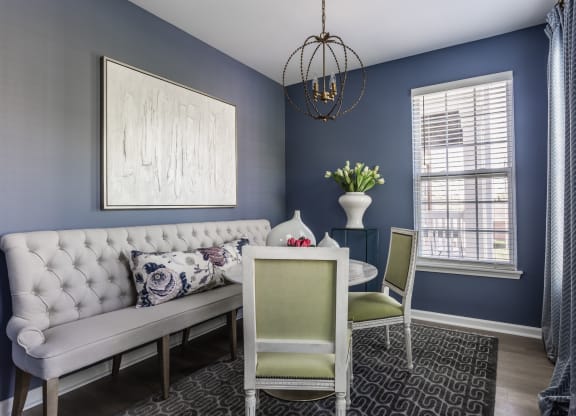 a flexspace with blue walls and a white couch and a table with two chairs at Alexandria of Carmel Apartments, Indiana, 46032