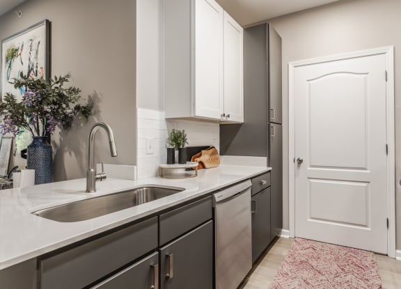 an empty kitchen with a sink and a door to a laundry room at Alexandria of Carmel Apartments, Carmel