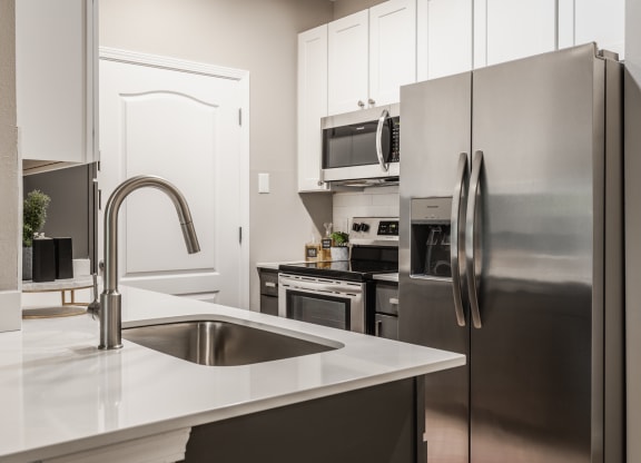 a kitchen with stainless steel appliances and a sink at Alexandria of Carmel Apartments, Indiana