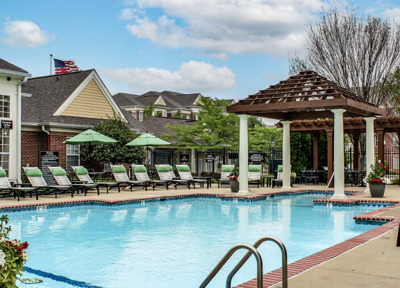 a swimming pool with lounge chairs and a pavilion at Alexandria of Carmel Apartments, Carmel