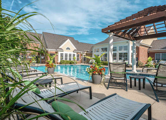 A poolside area with lounge chairs and a pool at Alexandria of Carmel Apartments, Carmel, Indiana
