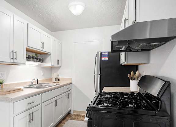 An upgraded kitchen with white cabinets and stainless steel appliances  at Apple Ridge Apartments, Walker, MI