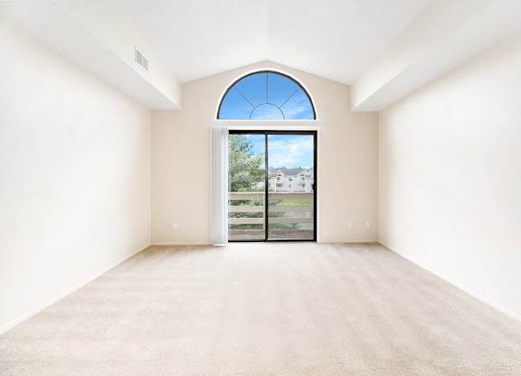 A living room with a large window and a high ceiling at Arbor Lakes Apartments in Elkhart, IN