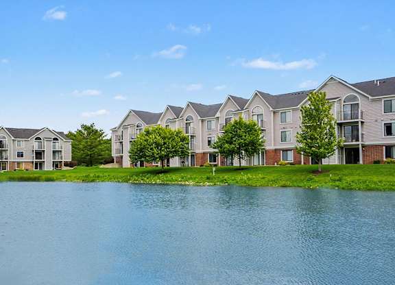A row of apartments with a body of water behind it at Arbor Lakes Apartments in Elkhart, IN