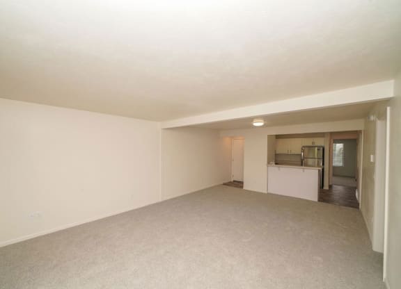 an empty living room with a kitchen in the backgroundat Arbor Lakes Apartments in Elkhart, IN