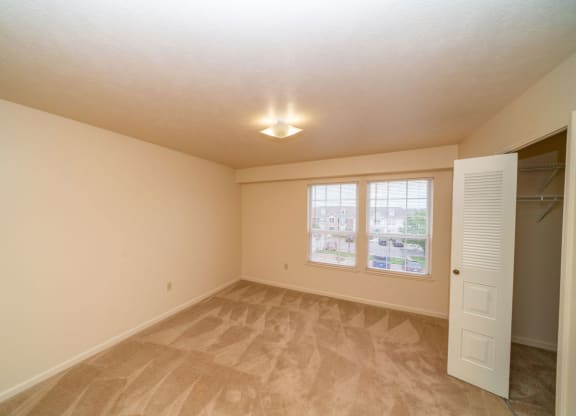 an empty bedroom with a walk-in closet and windows at Autumn Lakes Apartments and Townhomes, Mishawaka, IN