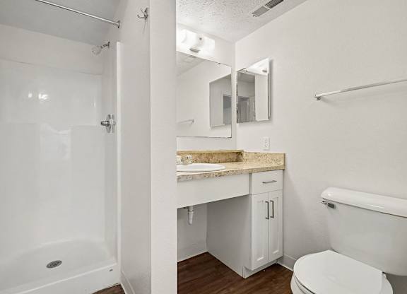 A white bathroom with a shower, toilet, and sink at Autumn Lakes Apartments and Townhomes, Mishawaka, 46544
