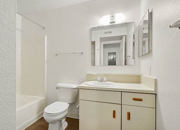 A bathroom with a toilet, sink, and mirror at Autumn Lakes Apartments and Townhomes, Mishawaka, 46544