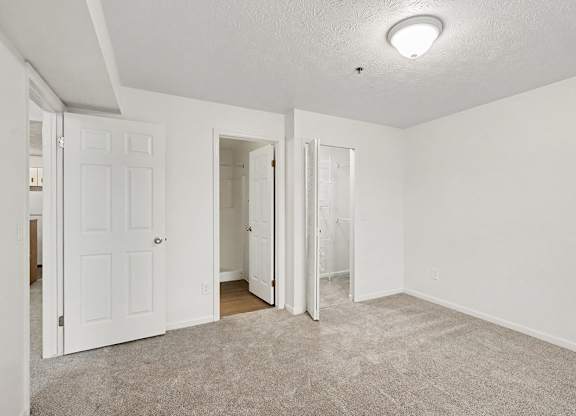 A bedroom with white walls, a walk-in closet and ensuite bathroom at Autumn Lakes Apartments and Townhomes, Mishawaka, 46544