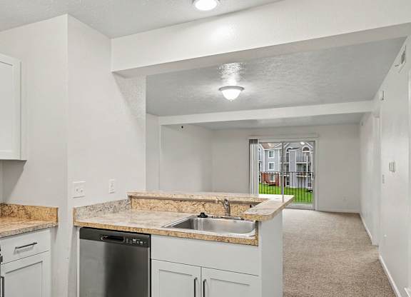 A kitchen with a breakfast bar and stainless steel appliances at Autumn Lakes Apartments and Townhomes, Mishawaka, 46544