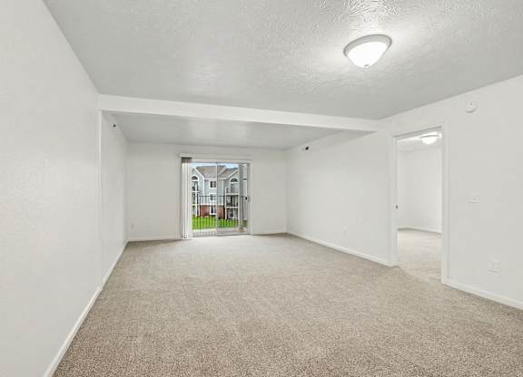 A spacious empty living room with carpeted floor and white walls at Autumn Lakes Apartments and Townhomes, Mishawaka, 46544
