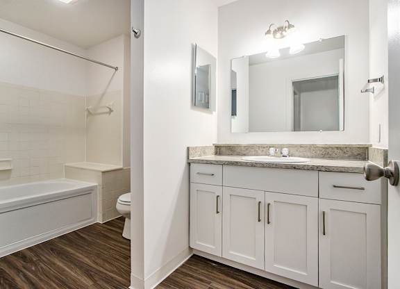 A white bathroom with a tub, toilet, and sink at Autumn Lakes Apartments and Townhomes, Mishawaka, 46544