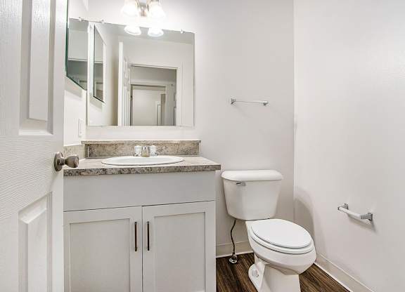 A white toilet sits next to a sink in a bathroom at Autumn Lakes Apartments and Townhomes, Mishawaka, 46544
