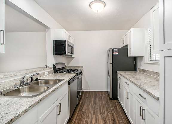 A kitchen with white cabinets and a black refrigerator at Autumn Lakes Apartments and Townhomes, Mishawaka, 46544