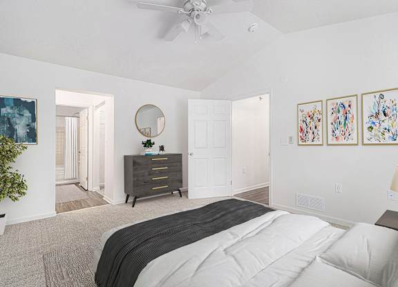 A bedroom with a large bed, a ceiling fan, and a high ceiling at Autumn Lakes Apartments and Townhomes, Mishawaka, 46544
