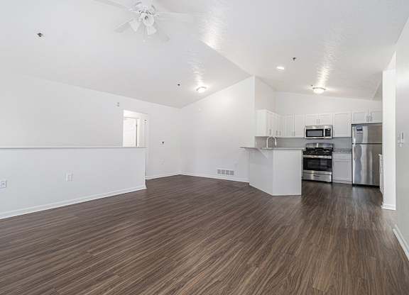 A large living and dining room with vinyl plank flooring and a kitchen in the background at Autumn Lakes Apartments and Townhomes, Mishawaka, 46544