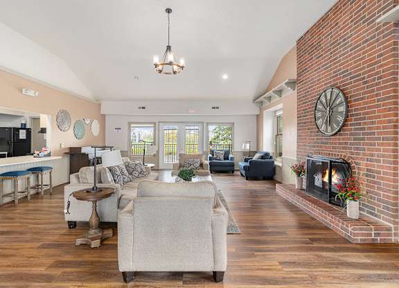 A community room with a fireplace and a couch at Autumn Lakes Apartments and Townhomes, Mishawaka, IN