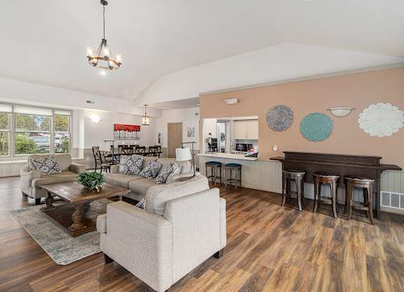 A community building with a white couch and a vinyl plank flooring at Autumn Lakes Apartments and Townhomes, Mishawaka, IN