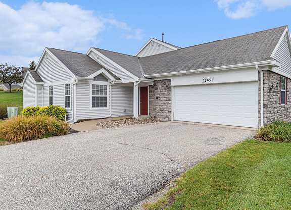 A townhome with a garage and a driveway in front at Autumn Lakes Apartments and Townhomes, Mishawaka, 46544