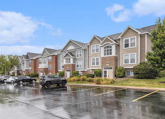 An exterior apartment building with cars parked in front at Autumn Lakes Apartments and Townhomes, Mishawaka, IN
