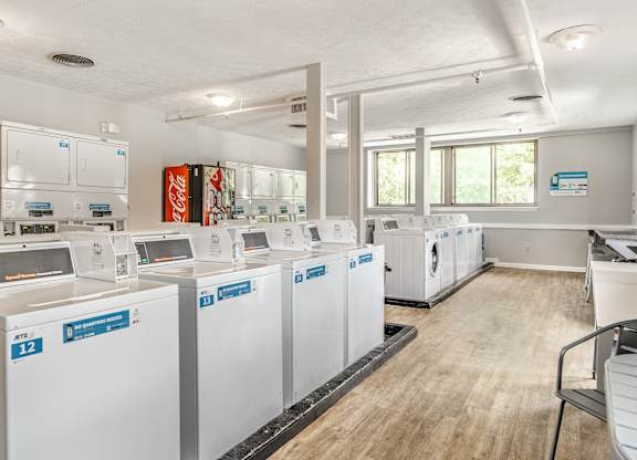 A laundromat with washers and dryers labeled E12