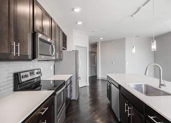 a renovated kitchen with white counter tops and dark wood cabinets at Avant & Avant II, Carmel, IN, 46032