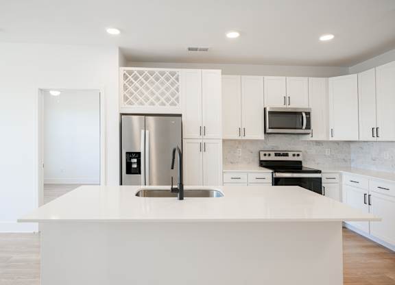 a large white kitchen with stainless steel appliances and white cabinets at Avant & Avant II, Carmel, IN, 46032