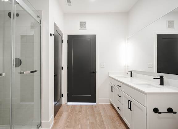 a bathroom with a sink and a shower and a black door at Avant & Avant II, Carmel, IN, 46032