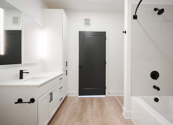 a bathroom with white cabinets and a black door     and a shower at Avant & Avant II, Carmel, IN, 46032