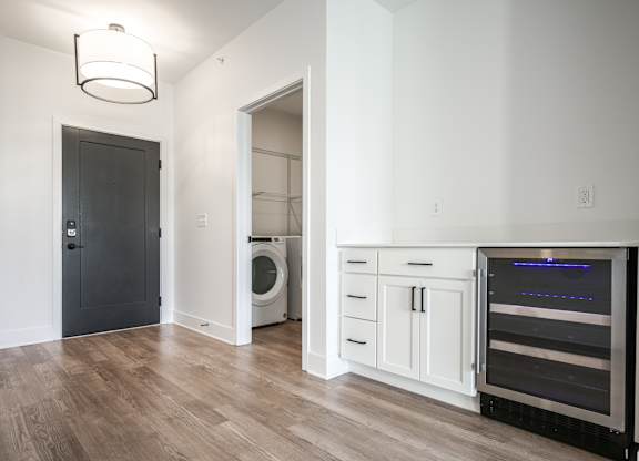 a living room with a washer and dryer and a door to a bathroom at Avant & Avant II, Carmel, IN, 46032