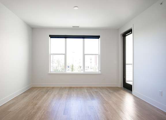 an empty living room with wood floors and a window at Avant & Avant II, Carmel, IN, 46032