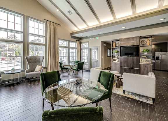 a living room with green chairs and a glass table at Avellan Springs Apartments, Morrisville, North Carolina