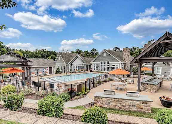 an outdoor pool with tables  at Avellan Springs Apartments, Morrisville