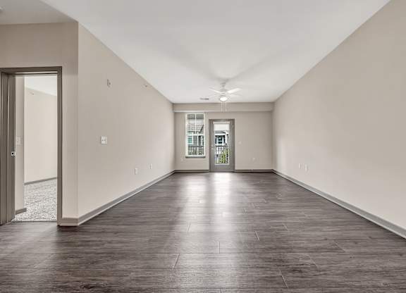 an empty living room with white walls and wood floors at Avellan Springs Apartments, Morrisville, North Carolina