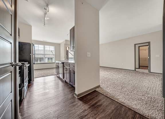 an open kitchen and living room with stainless steel appliances and wood flooring at Avellan Springs Apartments, North Carolina