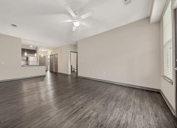 the living room and kitchen of a new home with white walls and wood floors at Avellan Springs Apartments, Morrisville, NC