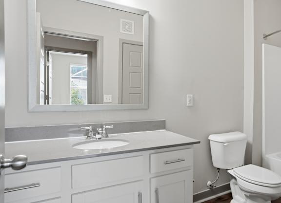 A white bathroom with a sink, toilet, and bathtub.