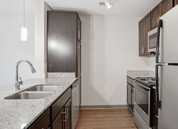 A kitchen with a sink and a refrigerator.