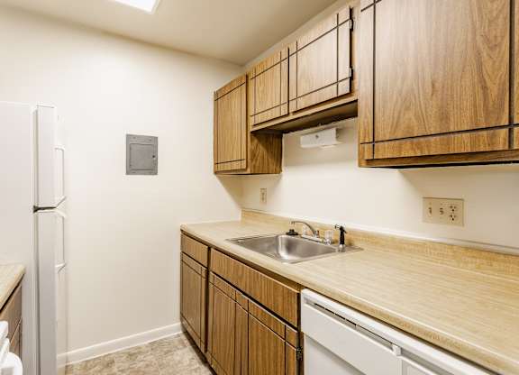 A kitchen with wooden cabinets and a white refrigerator