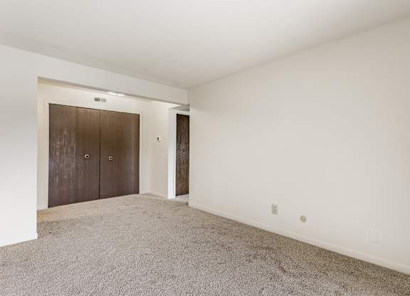 A room with a carpeted floor and a brown door