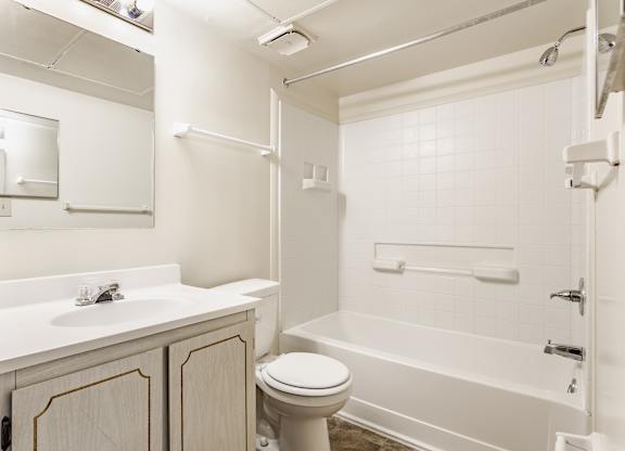 A white bathroom with a toilet, sink, and bathtub