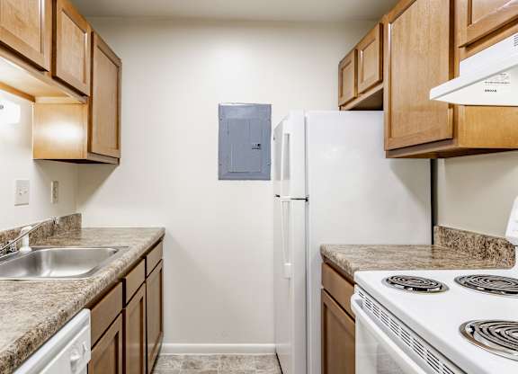 A kitchen with a white refrigerator and a stove top oven