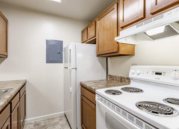 A kitchen with a white stove and a white refrigerator