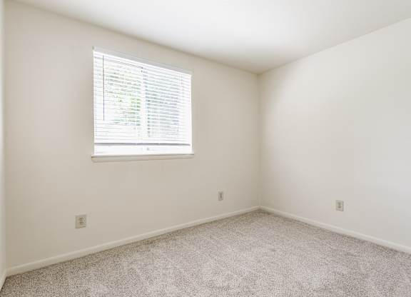 A room with a window and carpeted floor