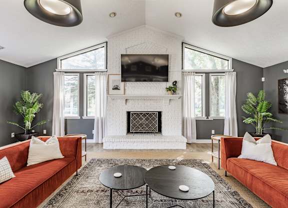 A living room with a fireplace and a television mounted above it